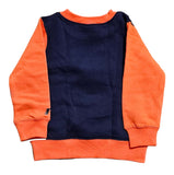 Orange and navy sweater on a cardboard background