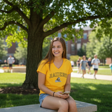 Woman in a yellow 'RAIDERS' shirt sitting on a bench outdoors